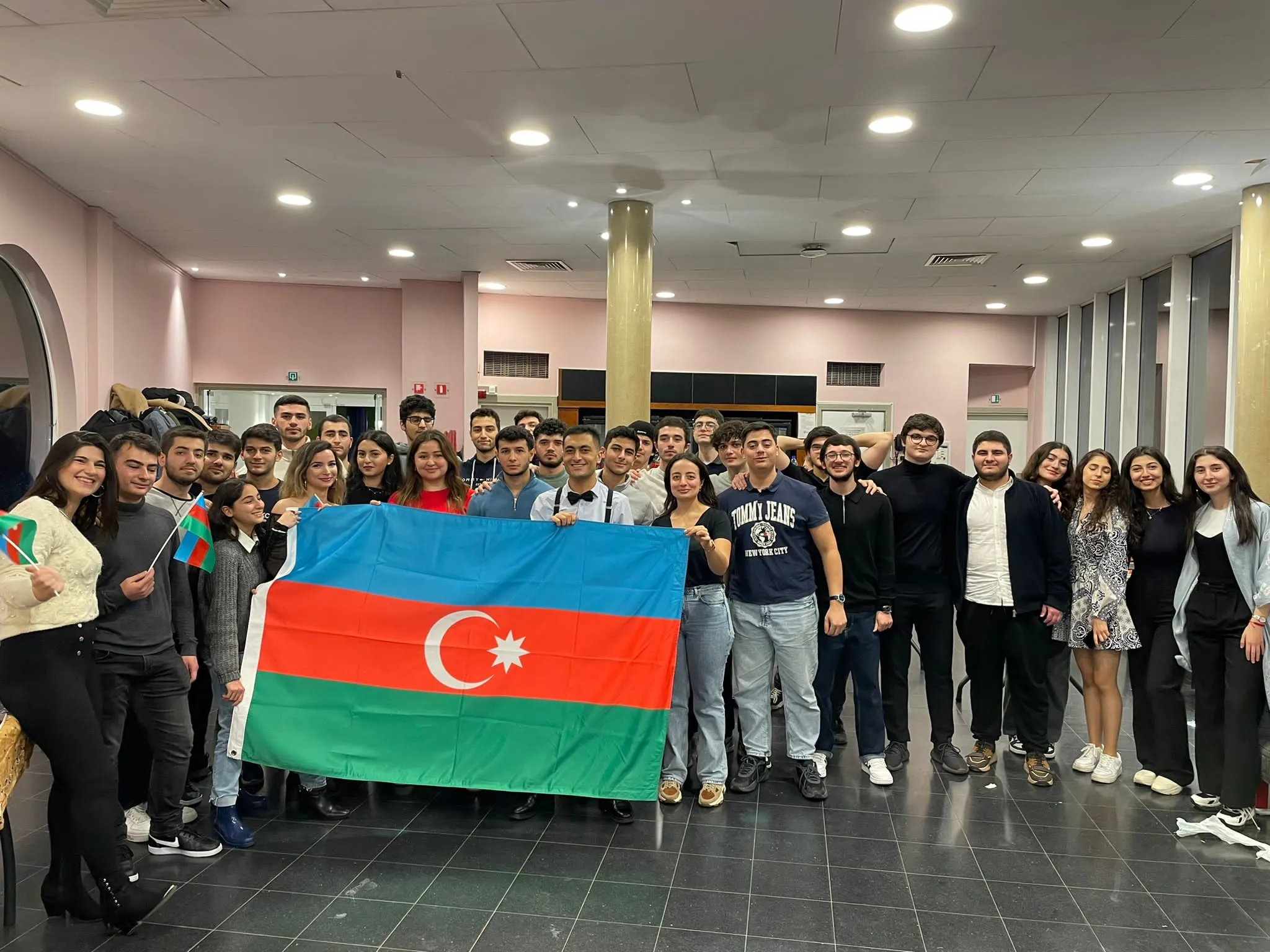 Des dizaines d'étudiants tiennent ensemble un grand drapeau azerbaïdjanais