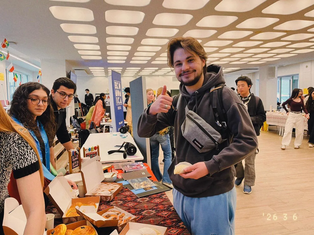 Un visiteur, şəkərbura à la main, lève le pouce devant le stand de l'IRS
