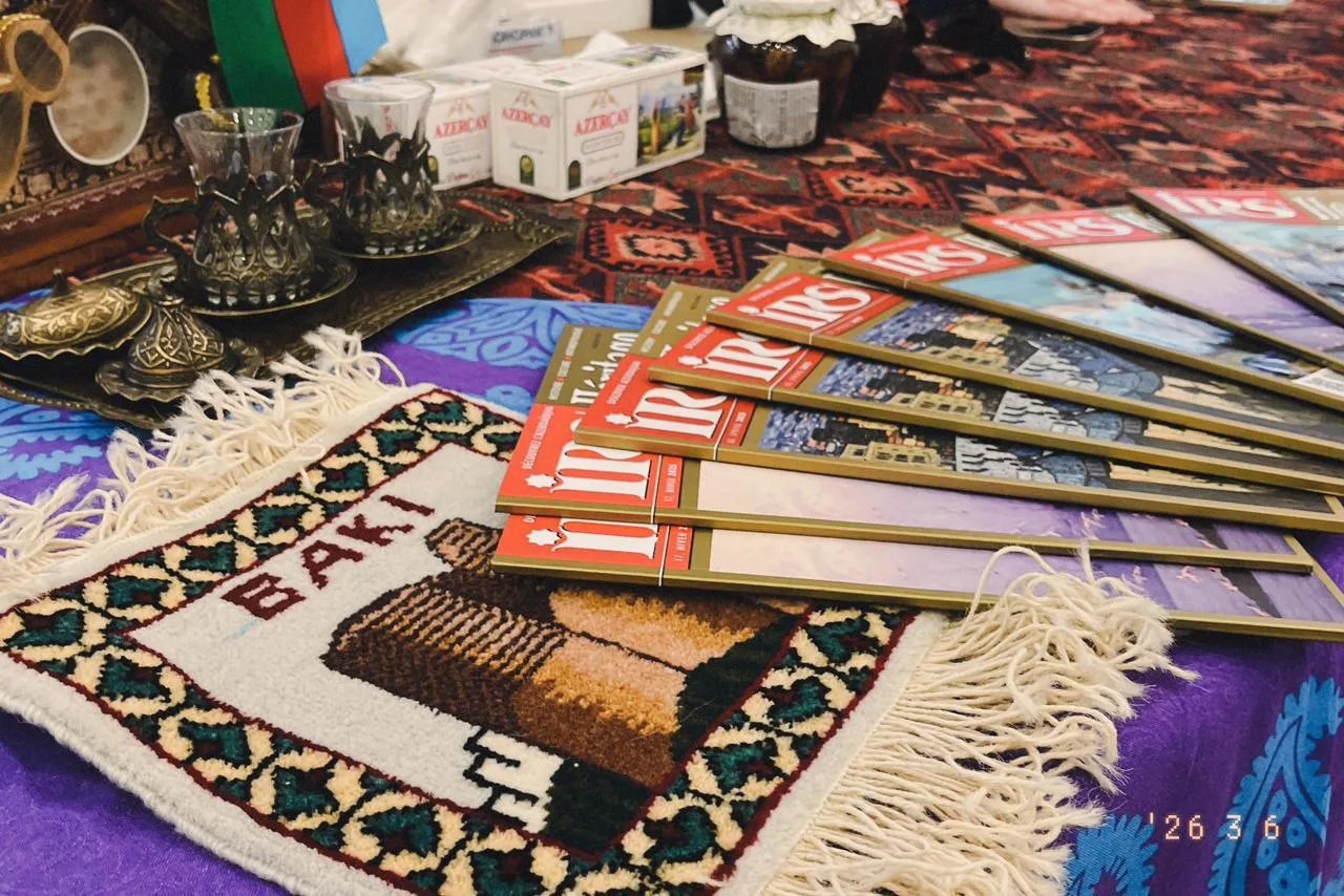 Verres à thé armudu, petit tapis « Bakı » et magazines IRS disposés sur le stand