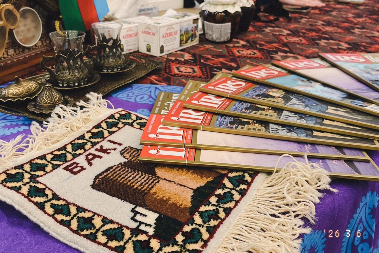 Verres à thé armudu, petit tapis « Bakı » et magazines IRS disposés sur le stand